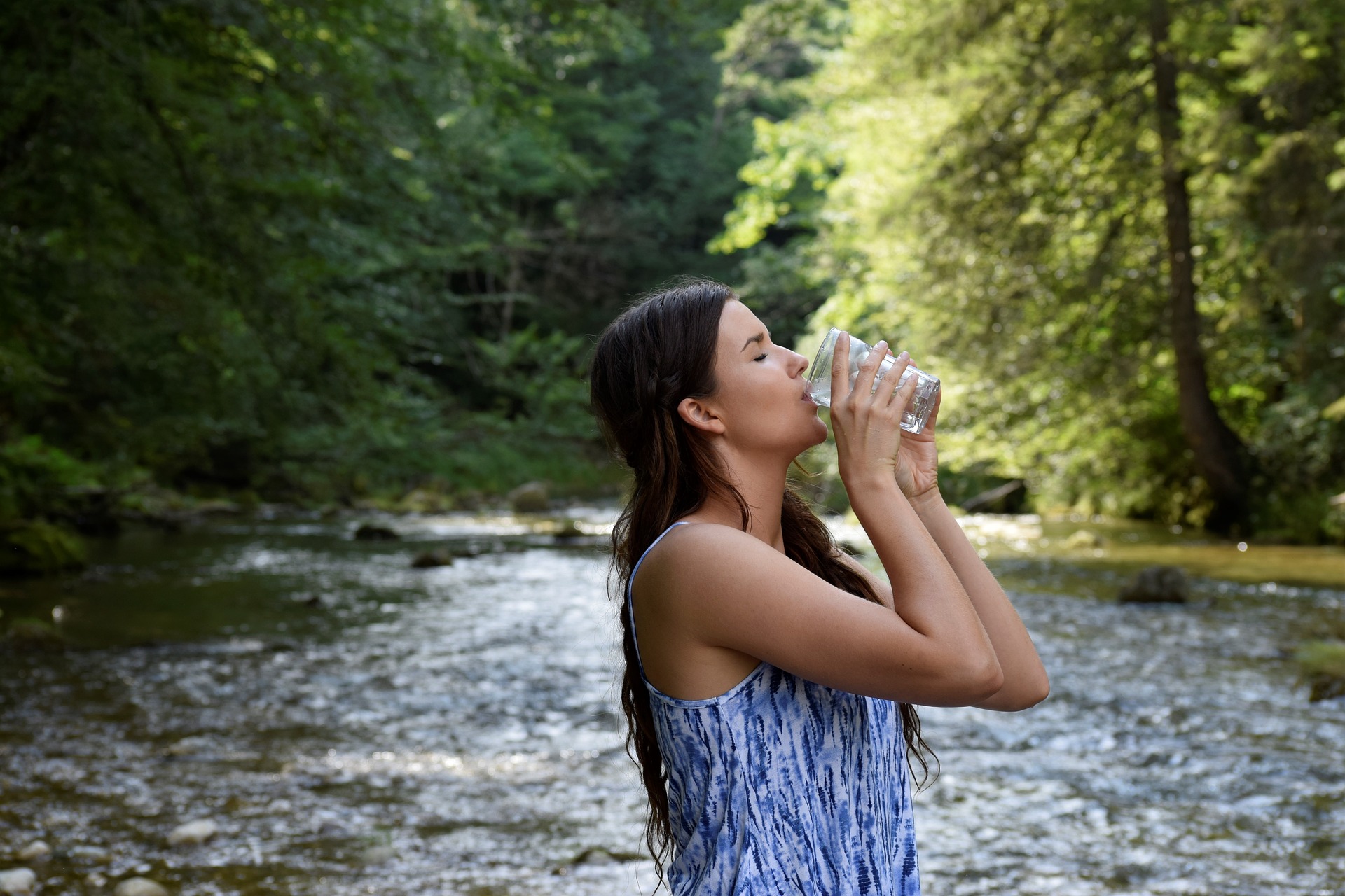 Person drinking water near river