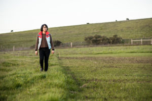 Photo of seed farmer Mai Nguyen walking on their farm operation land in Petaluma, CA. Photo by Lance Cheung, US Department of Agriculture.