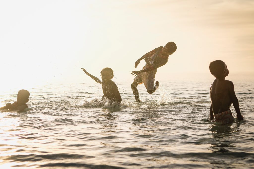 Four children playing in a lake. 