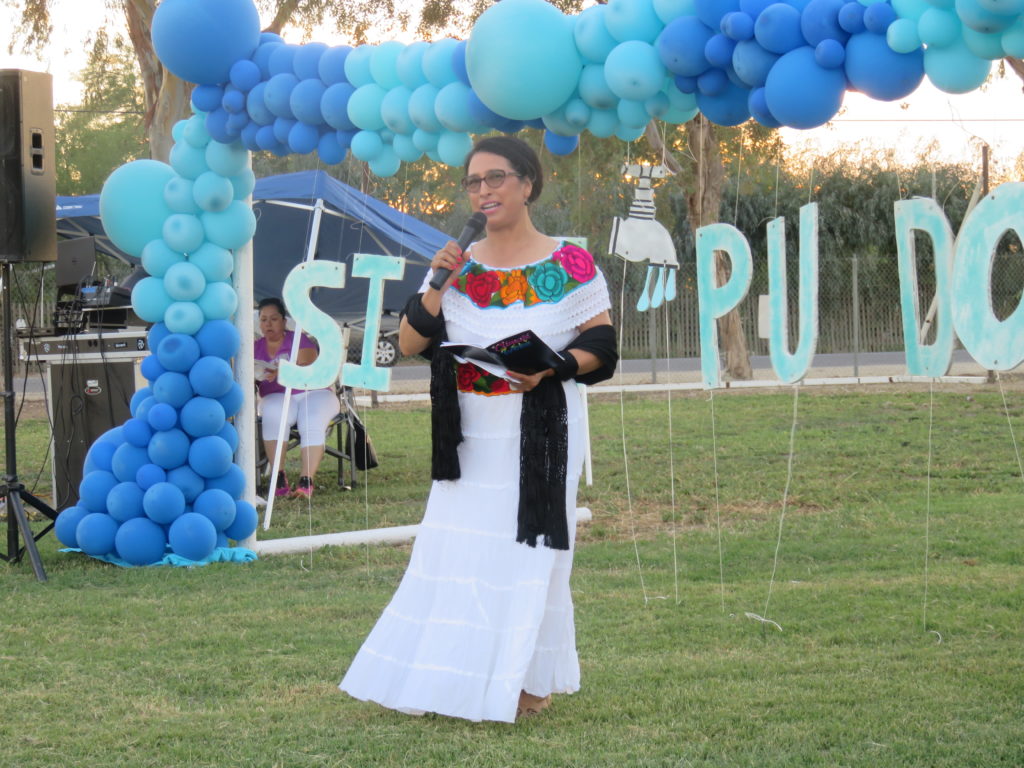 Isabel Solorio, from Lanare, CA, speaks at a community celebration of the Safe and Affordable Drinking Water Fund. The decorations in the background read "Sí, se pudo." Photo by Leadership Counsel for Justice and Accountability. 