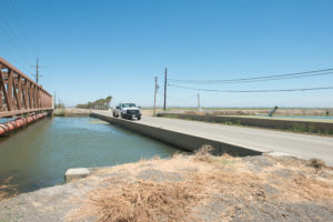 A bridge crossing over Outside Canal in Firebaugh, California, has subsided until there is almost no space between the bottom of the bridge decking and the canal water surface. Photo by Florence Low / California Department of Water Resources.